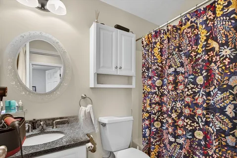 a bathroom with a granite countertop sink and a mirror