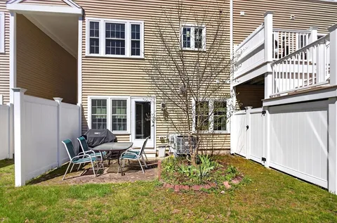 a view of backyard with a chair and table in the patio