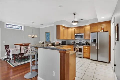 a kitchen with kitchen island granite countertop a stove refrigerator and cabinets