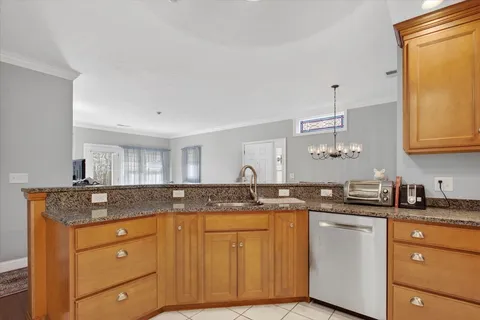 a kitchen with granite countertop cabinets stainless steel appliances a sink and a window