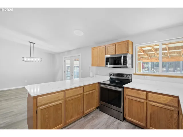 a kitchen with granite countertop cabinets stainless steel appliances and a window