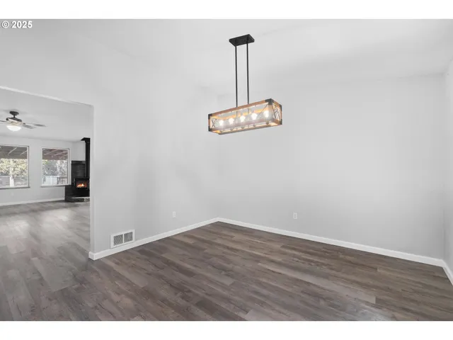 a view of a room with wooden floor and stainless steel appliances