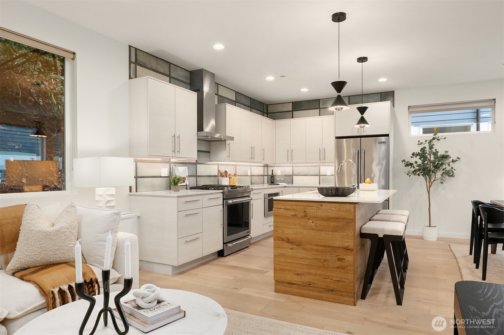 2617 3rd Avenue West Seattle, WA 98119 - Photo 20 of 30 a kitchen with stainless steel appliances kitchen island granite countertop a stove a sink a dining table and chairs with wooden floor