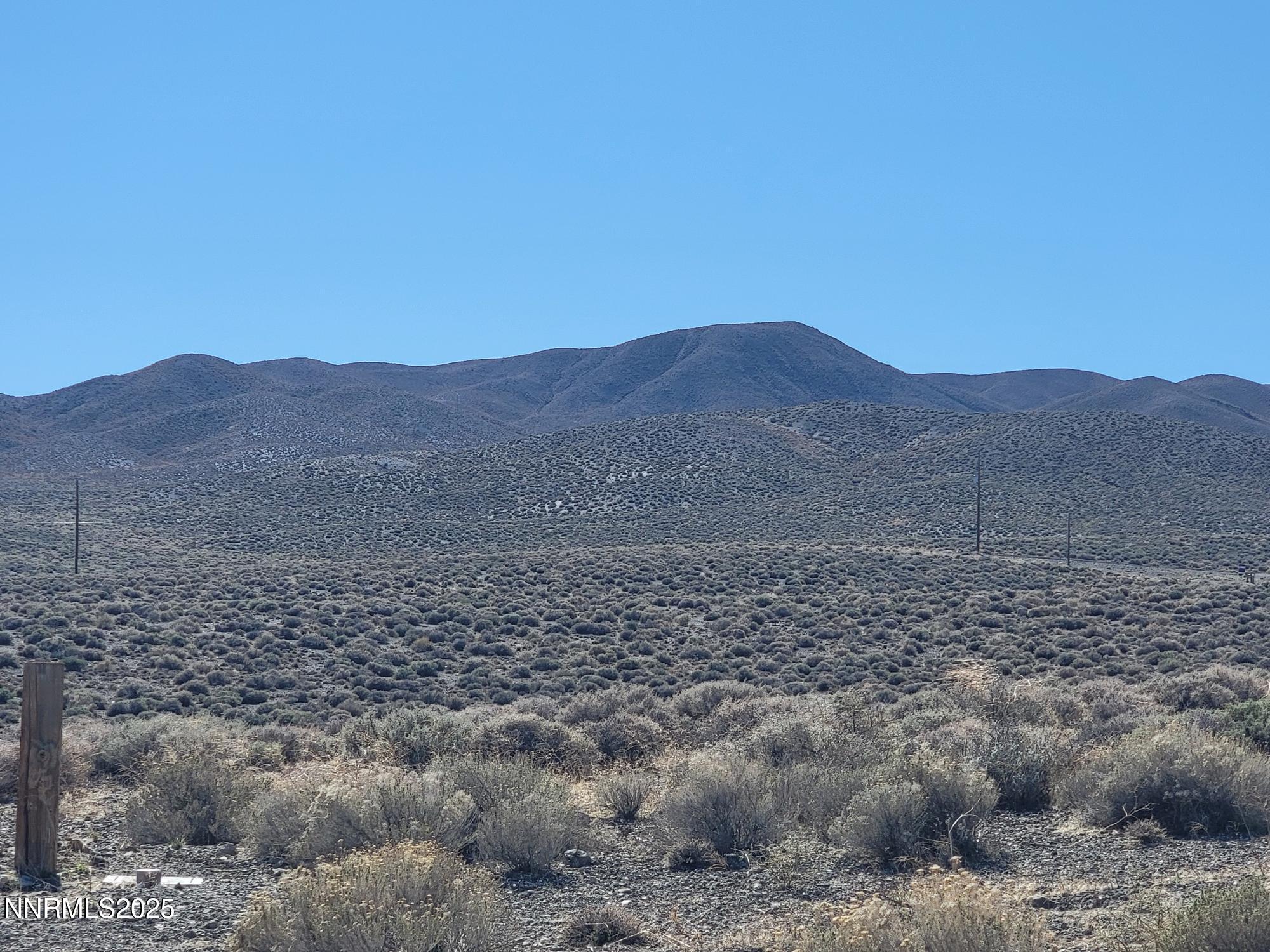 3090 Curtis Avenue Silver Springs, NV 89429 - Photo 10 of 17 a view of a dry yard with mountains in the background