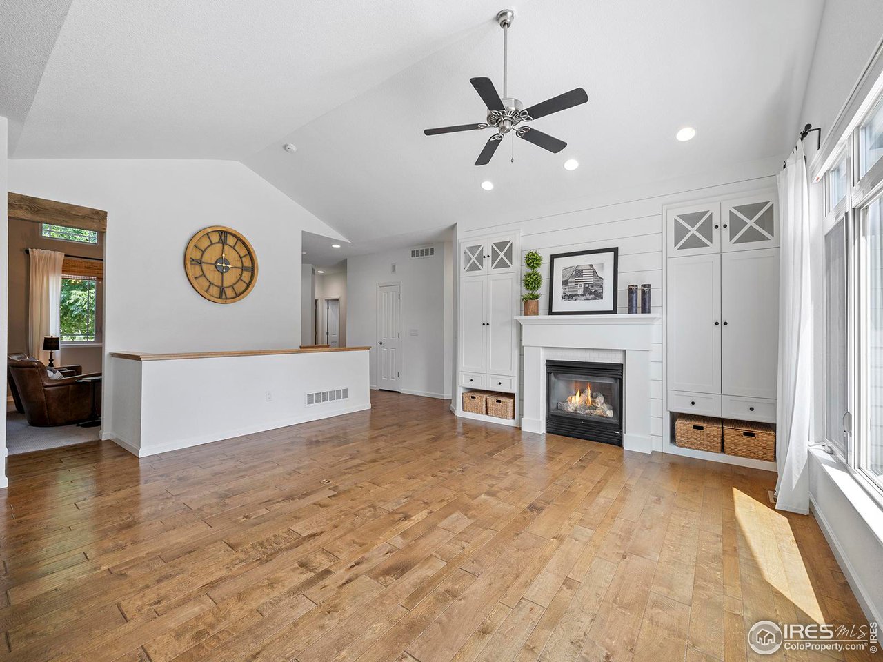 6427 Half Moon Bay Drive Windsor, CO 80550 - Photo 12 of 33 a view of a livingroom with a fireplace a ceiling fan and windows