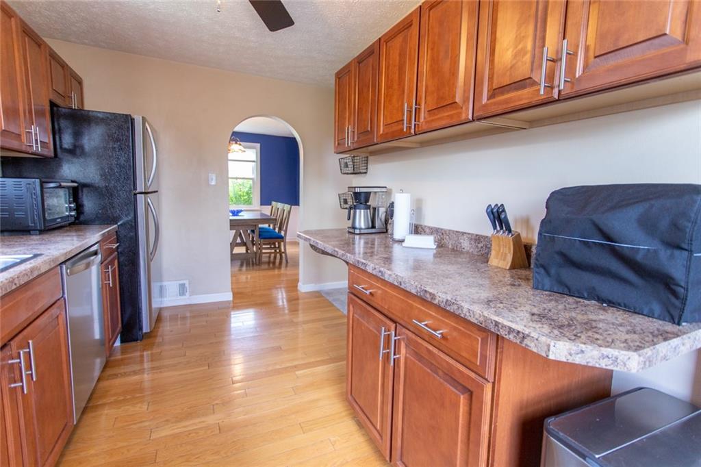 3211 Willett Road Pittsburgh, PA 15227 - Photo 8 of 27 a kitchen with stainless steel appliances granite countertop a stove a sink dishwasher and cabinets with wooden floor