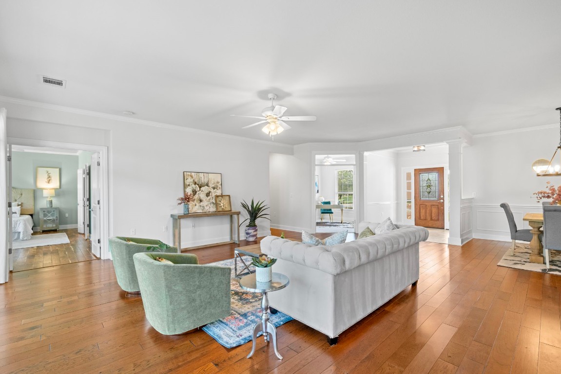 a living room with furniture and wooden floor