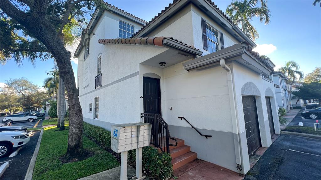735 Southwest 148th Avenue, Unit 1702 Davie, FL 33325 - Photo 1 of 15 a view of a white house with a small yard and a large tree