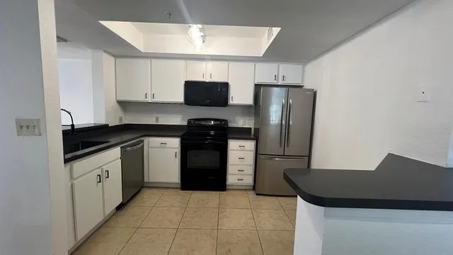 a kitchen with a refrigerator and a stove top oven