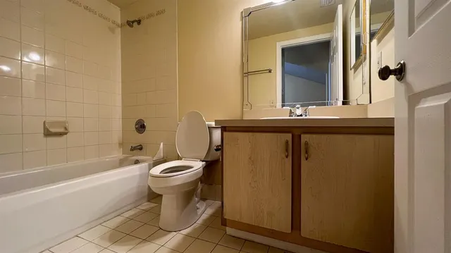 a bathroom with a granite countertop toilet a sink and bathtub