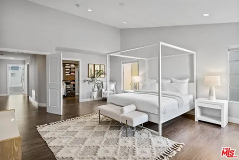 a bedroom with a bed and a wooden floor