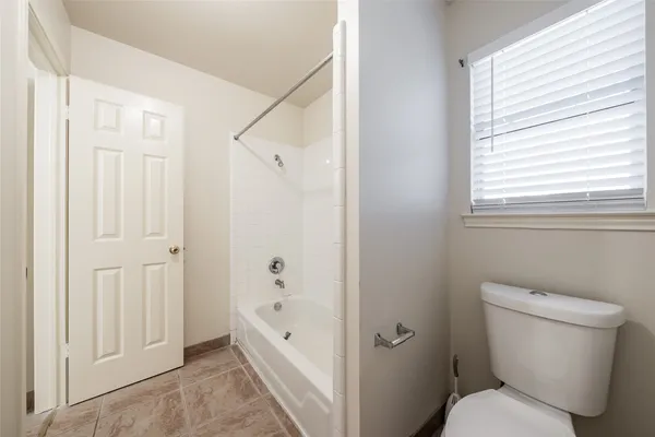 a bathroom with a toilet and a tub