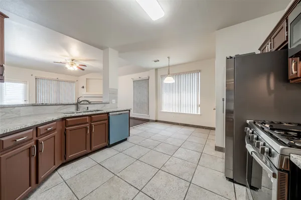a large kitchen with stainless steel appliances granite countertop a stove a sink and a refrigerator
