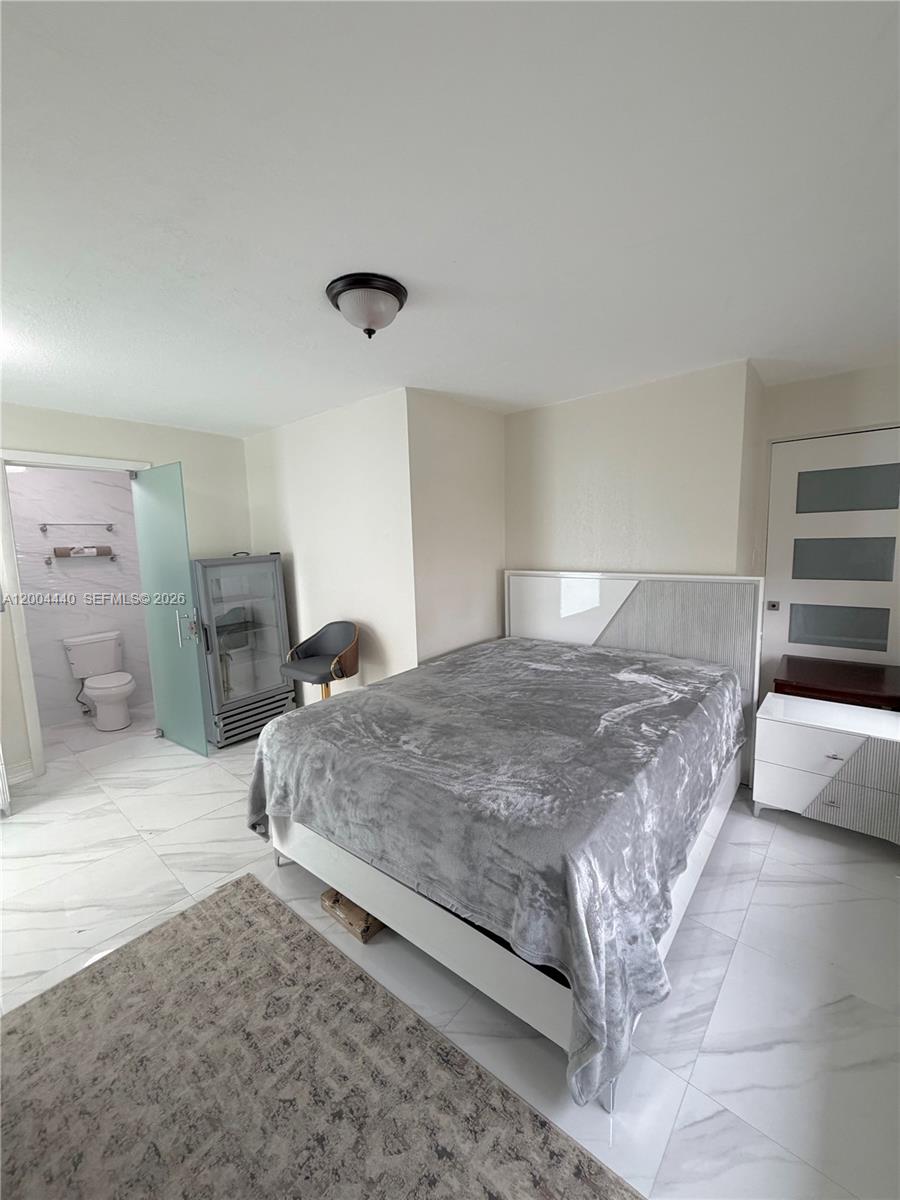 5801 Northwest 113th Terrace, Unit 4 Hialeah, FL 33012 - Photo 2 of 8 a bedroom with a large bed and a couch