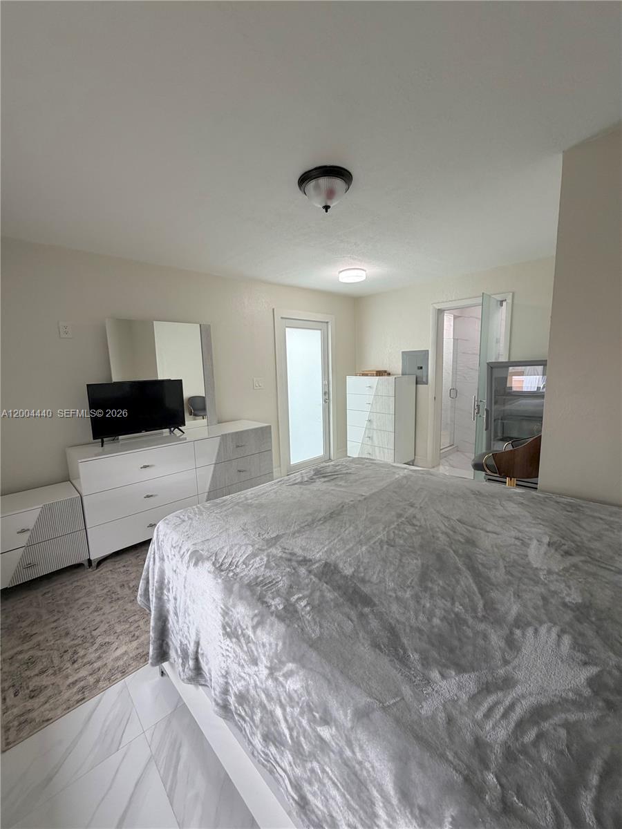 5801 Northwest 113th Terrace, Unit 4 Hialeah, FL 33012 - Photo 3 of 8 a spacious bedroom with a bed and couch