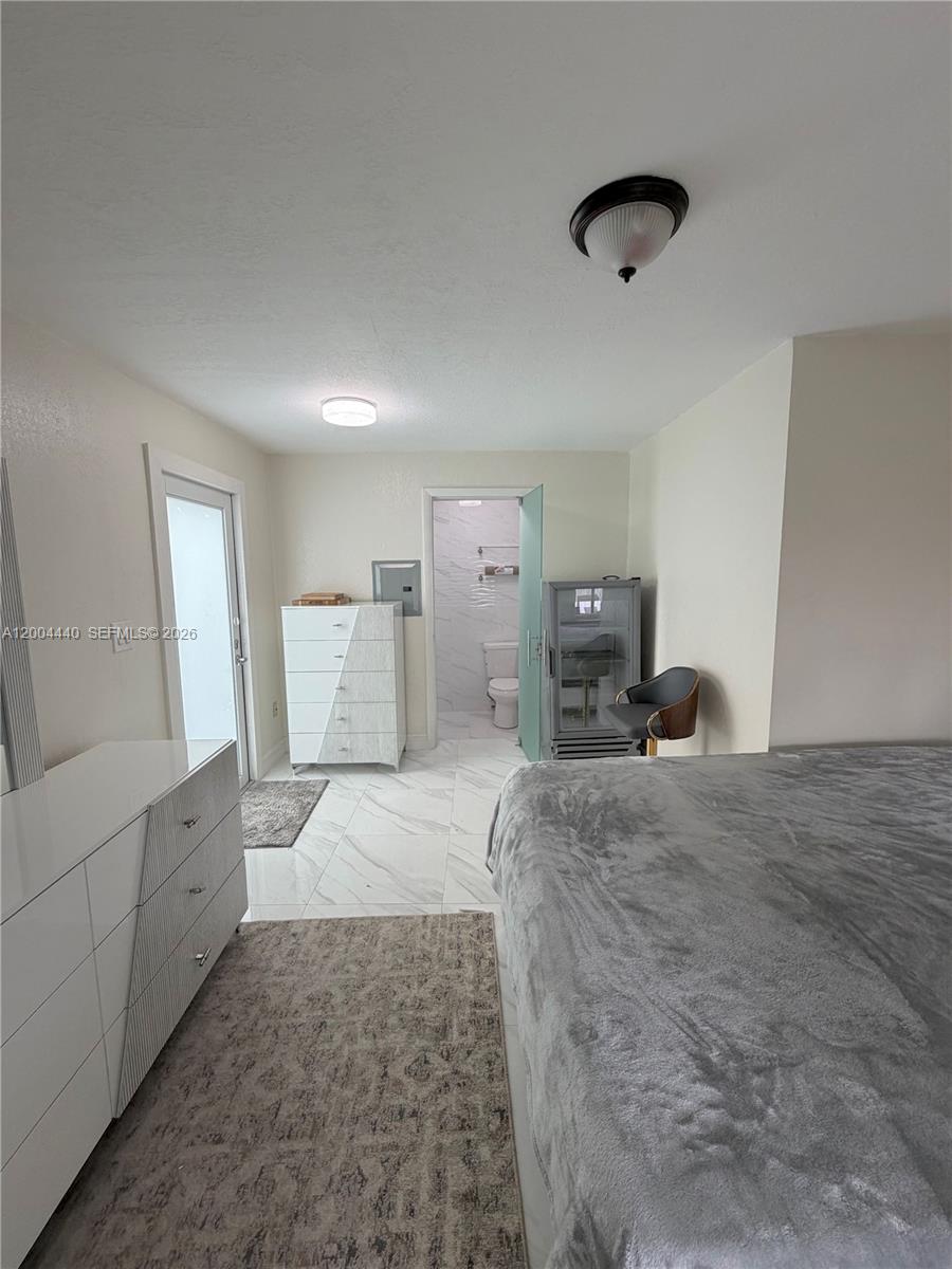 5801 Northwest 113th Terrace, Unit 4 Hialeah, FL 33012 - Photo 4 of 8 a bed room with a bed and a television