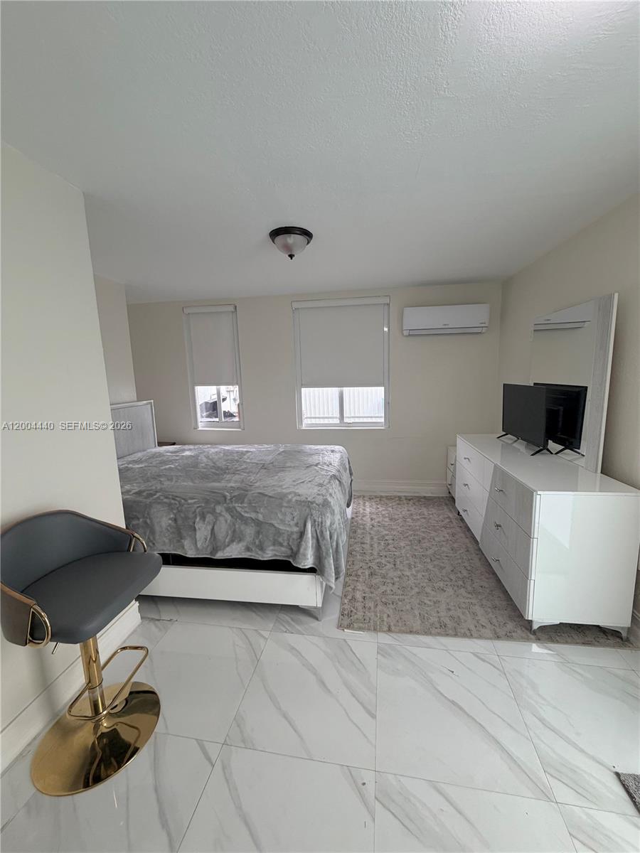 5801 Northwest 113th Terrace, Unit 4 Hialeah, FL 33012 - Photo 5 of 8 a bedroom with a bed and a chair