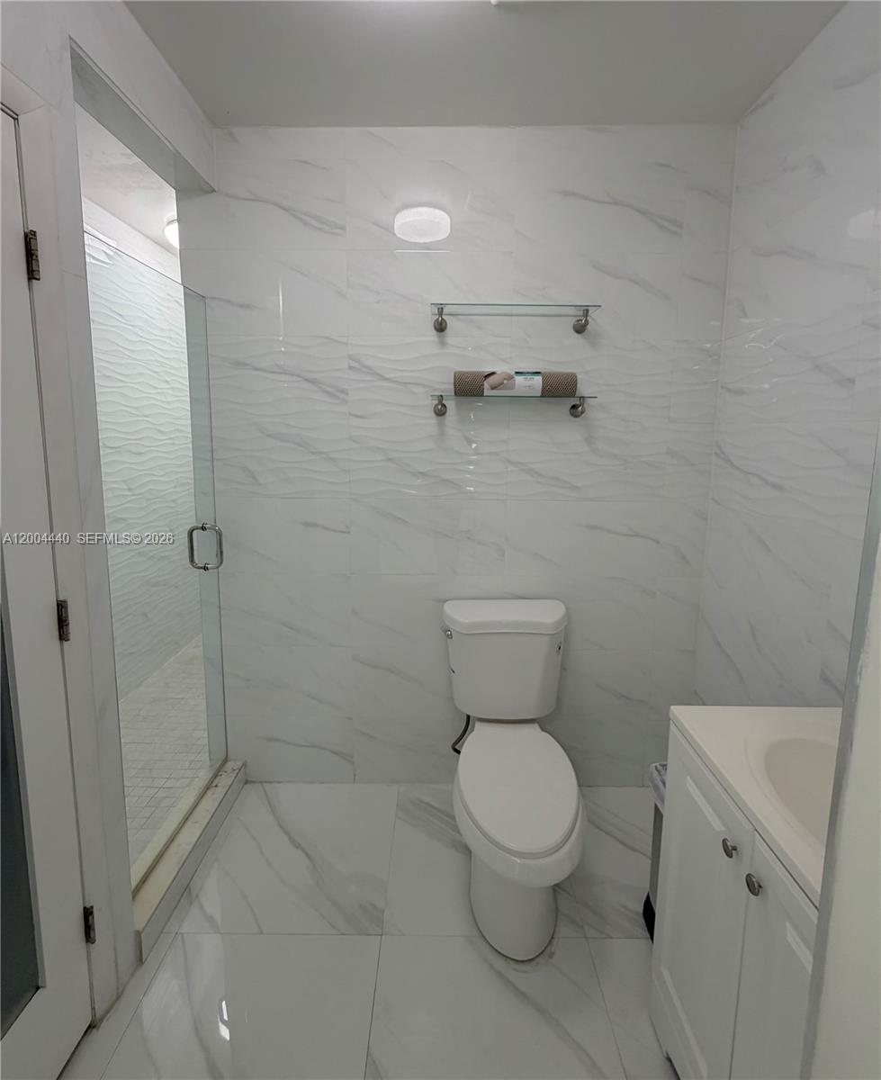 5801 Northwest 113th Terrace, Unit 4 Hialeah, FL 33012 - Photo 6 of 8 a white toilet sitting next to a bathroom sink