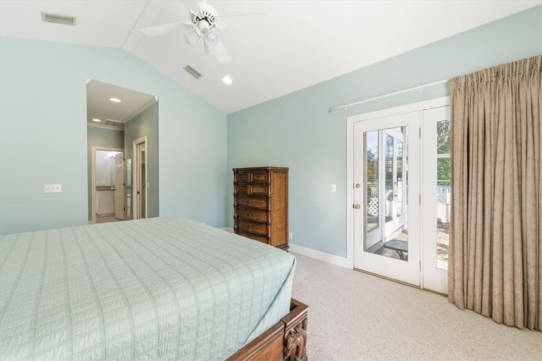 805 King's Grant St. Simons Island, GA 31522 - Photo 23 of 50 The primary suite is large and offers doors opening to the screened-in porch.