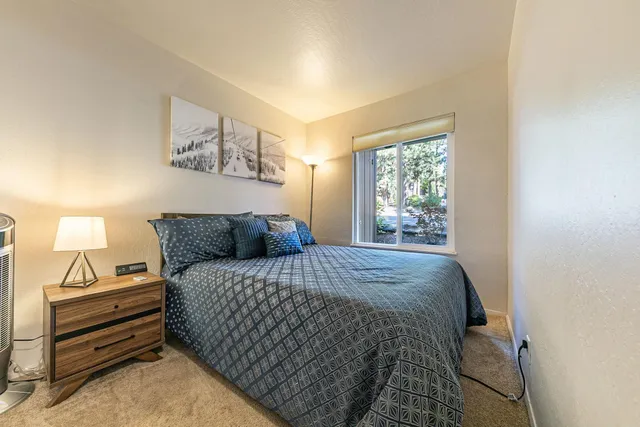 a bed sitting in a bedroom next to a window