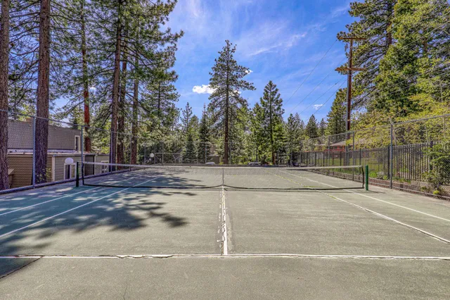 a view of a tennis court with trees in the background