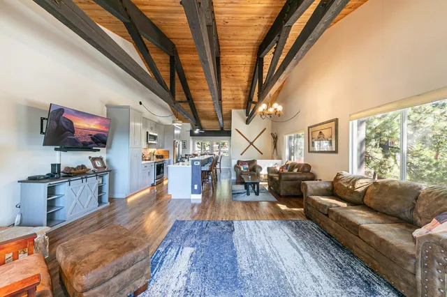a living room with furniture a flat screen tv and a large window
