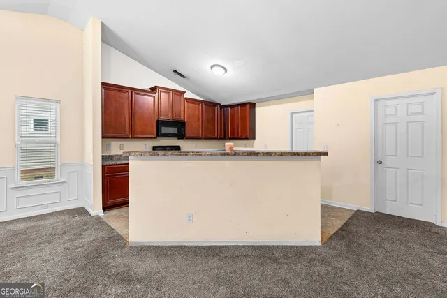 a kitchen with stainless steel appliances granite countertop a stove top oven a sink and a refrigerator