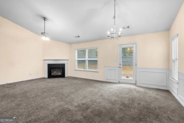 a view of an empty room with a fireplace and a window