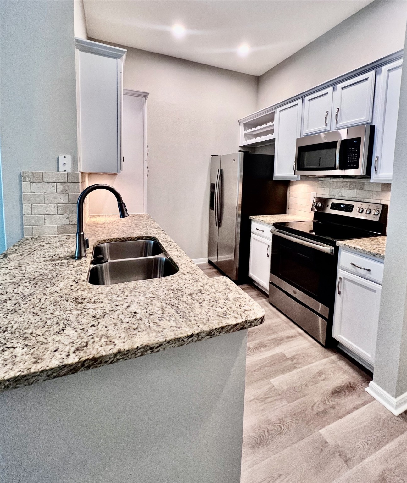 5353 Memorial Drive, Unit 4075 Houston, TX 77007 - Photo 1 of 24 a kitchen with stainless steel appliances granite countertop a sink a stove top oven and refrigerator