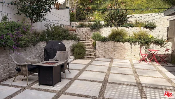 a view of a patio with table and chairs with wooden fence and plants