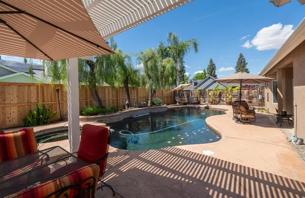 a view of swimming pool with outdoor seating and a patio