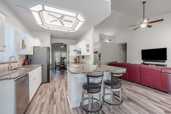 a view of a dining room with furniture a kitchen and chandelier
