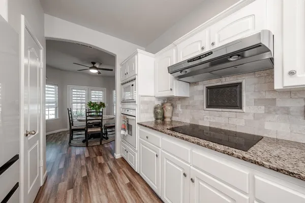 a kitchen with granite countertop a sink stove and cabinets