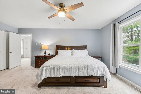 a bedroom with a bed a window and a chandelier