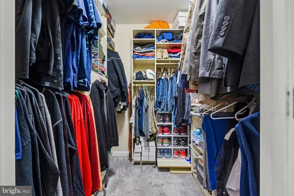 a view of walk in closet with clothes