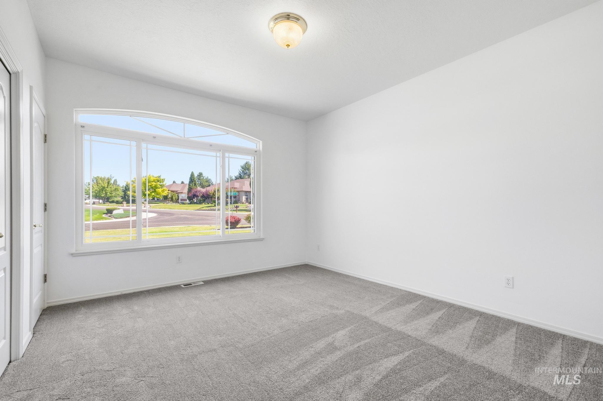 15181 Drury Way Caldwell, ID 83607 - Photo 29 of 49 Spacious room with light gray carpeting, crisp white walls, and a large arched picture window