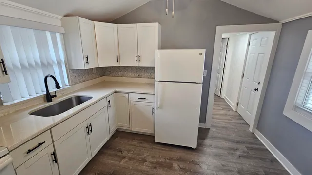 a kitchen with white cabinets and white appliances