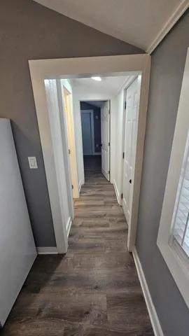 a view of a hallway with wooden floor and staircase