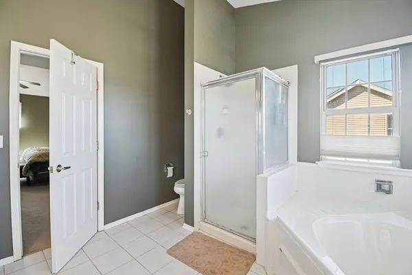 a large white bathroom with a large tub sink vanity and window
