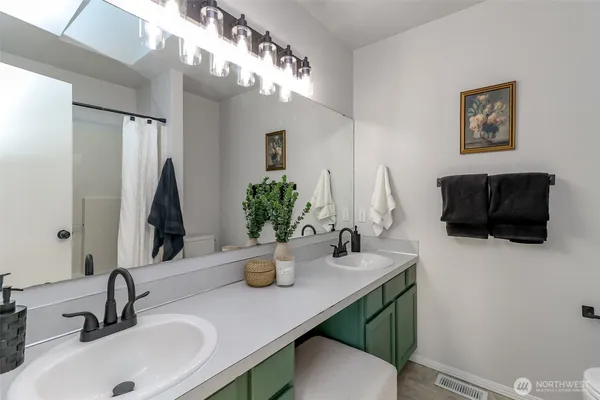 a bathroom with a sink a potted plant and a mirror