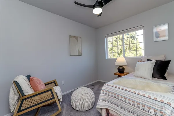 a bedroom with a bed chair and window