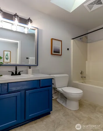 a bathroom with a toilet a sink and mirror