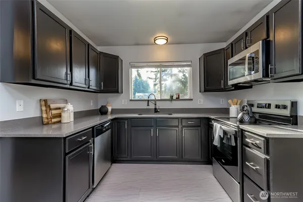 a kitchen with stainless steel appliances granite countertop a sink stove and microwave