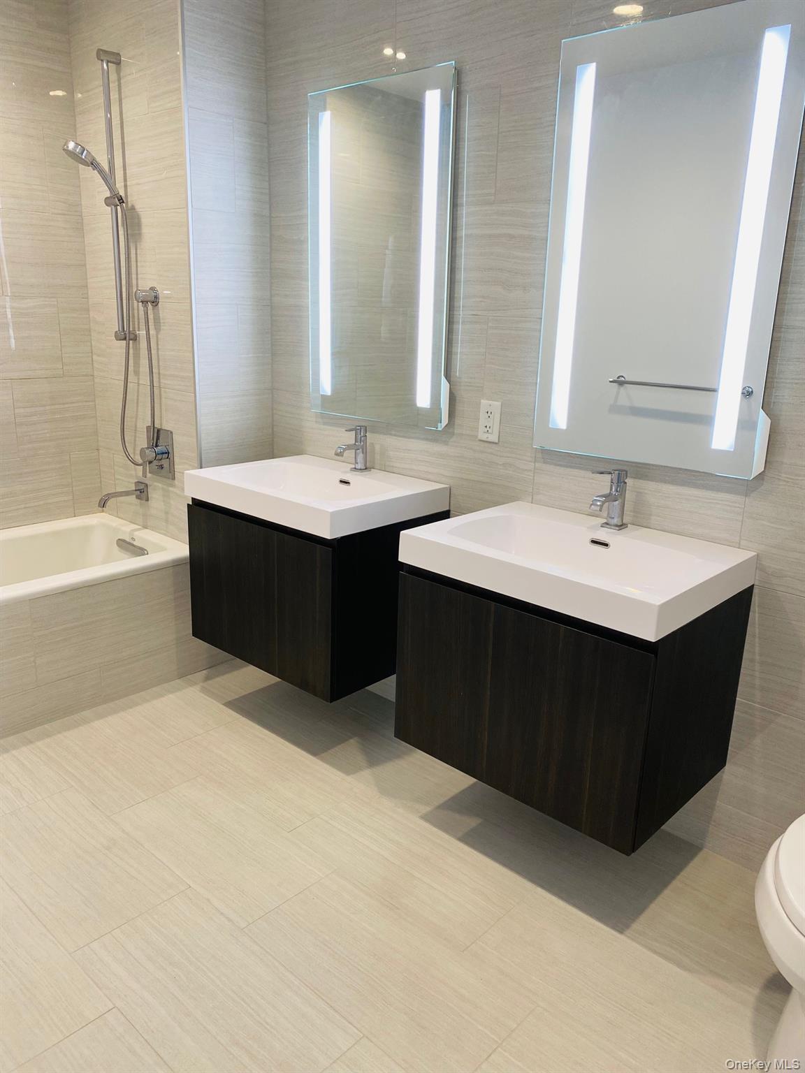 131-03 40 Road, Unit 8J Queens, NY 11354 - Photo 12 of 26 a bathroom with a sink double vanity and a bathtub