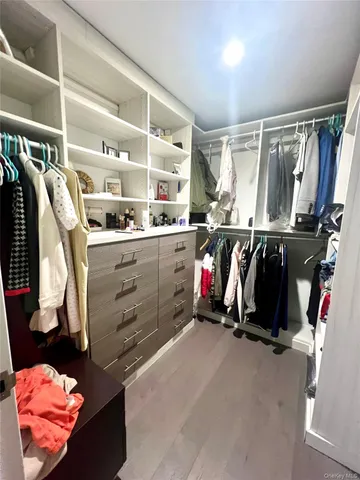 a view of walk in closet with clothes and shoes