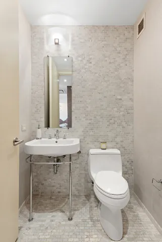 a bathroom with a toilet a sink and mirror