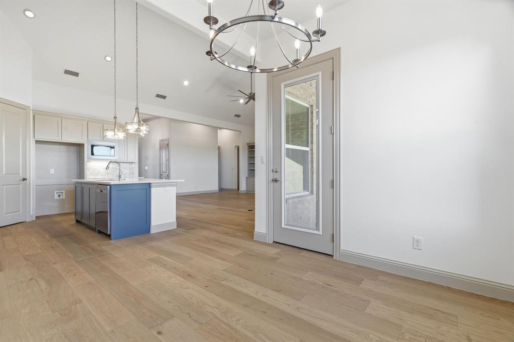 113 Rockford Street Rhome, TX 76078 - Photo 12 of 27 a kitchen with kitchen island stainless steel appliances a chandelier and refrigerator