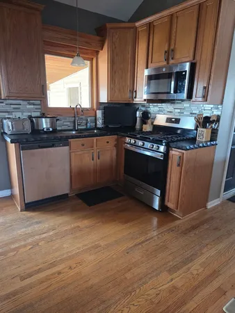 a kitchen with granite countertop stainless steel appliances and wooden cabinets