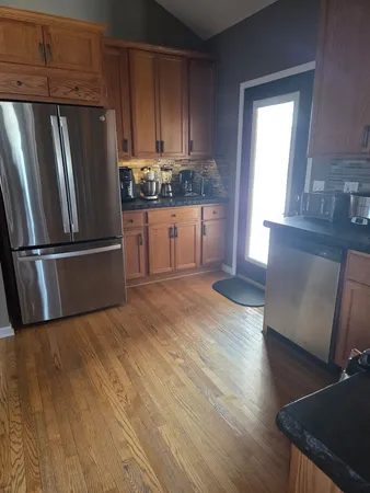 a kitchen with granite countertop wooden floors and stainless steel appliances
