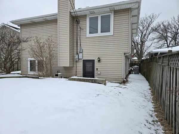 a view of a house with a yard covered in snow